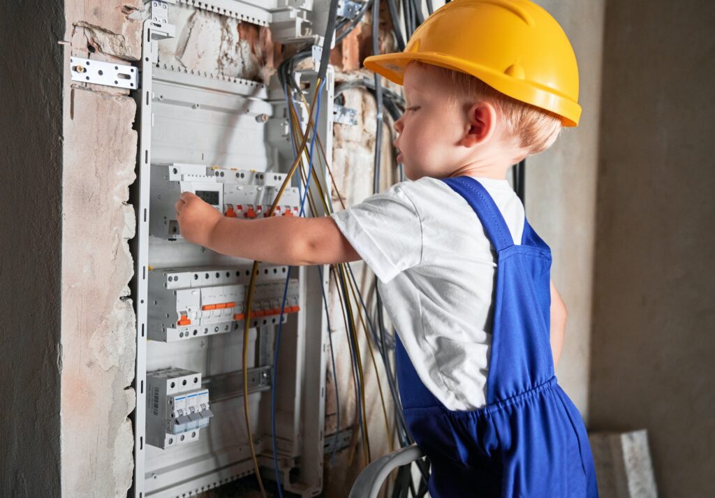 Little boy repairing electrical control panel at home.